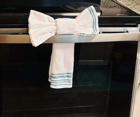 Kitchen towel folded into a decorative bow on an oven